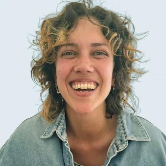 Sorriso feliz de uma mulher com cabelo cacheado em ambiente de bem-estar e relaxamento na Lotus Studio, centro de tratamentos de saúde e bem-estar.