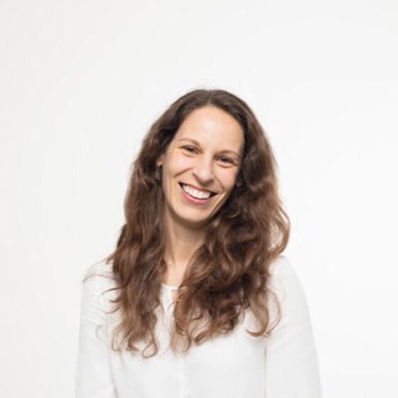 Sorriso de mulher com cabelo castanho claro, expressão feliz, fundo branco, representando bem-estar e relaxamento no centro de bem-estar Lotus Studio.